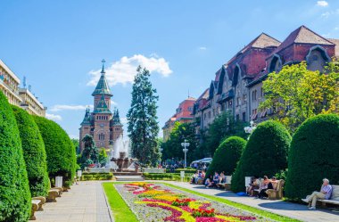 TIMISOARA, ROMANIA, 4 Temmuz 2015: Zafer Meydanı - Piata Victoriei - Timisoara, bir tarafında ulusal opera, diğer tarafında ise metropol katedrali ile çevrili yeşil parkın bulunduğu uzun bir meydandır..