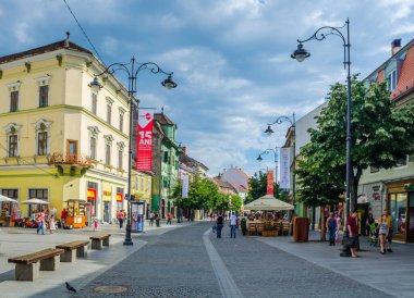 SIBIU, ROMANIA, JULY 6, 2015: people stroll along the boulevard nicolae balcescu or enjoy a sunny day in the Great Square, the largest square in the upper town and an architectural monument by UNESCO.