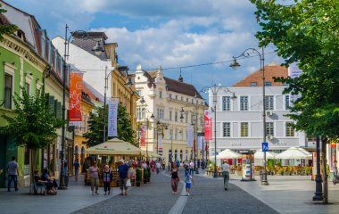SIBIU, ROMANIA, 6 HAZİRAN 2015: İnsanlar Nicolae Balcescu bulvarı boyunca yürüyor ya da Büyük Meydan 'da güneşli bir günün tadını çıkarıyorlar, üst şehrin en büyük meydanı ve UNESCO tarafından yapılmış bir mimari anıt..