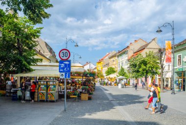 SIBIU, ROMANIA, 6 HAZİRAN 2015: İnsanlar Nicolae Balcescu bulvarı boyunca yürüyor ya da Büyük Meydan 'da güneşli bir günün tadını çıkarıyorlar, üst şehrin en büyük meydanı ve UNESCO tarafından yapılmış bir mimari anıt..