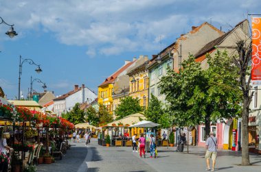 SIBIU, ROMANIA, JULY 6, 2015: people stroll along the boulevard nicolae balcescu or enjoy a sunny day in the Great Square, the largest square in the upper town and an architectural monument by UNESCO.