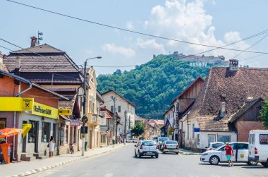 RASNOV, ROMANIA, 8 Temmuz 2015: Tepedeki Ortaçağ kalesi, Rasnov, Transilvanya, Romanya 'daki kasaba adı ve kilisesiyle imzala