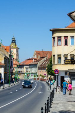 BRASOV, ROMANIA, 9 Temmuz 2015: Romanya 'nın Brasov kentindeki belediye binasının parlayan kulesiyle George Baritiu caddesinin manzarası.