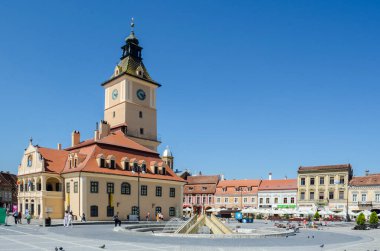 BRASOV, ROMANIA, 6 Temmuz 2015: Council Square şehrin tarihi merkezidir, insanlar açık teras ve restoranlarda yürüyor ve oturuyorlar.