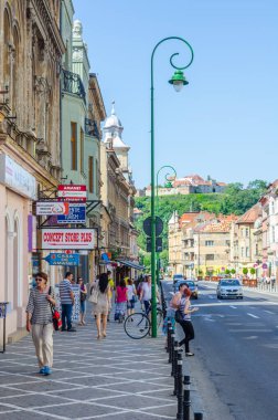 BRASOV, ROMANIA, 9 Temmuz 2015: Romanya 'nın Brasov kentindeki belediye binasının parlayan kulesiyle George Baritiu caddesinin manzarası.