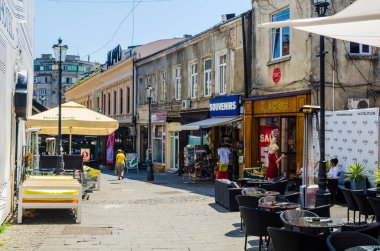 BUCHAREST, ROMANIA, JULY 11, 2015: view of a minor street inside of the old town of romanian capital bucharest where people usually relax during hot summer days.