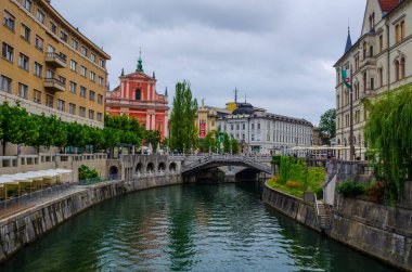 LJUBLJANA, SLOVENIA, JULY 29, 2015: Old town embankment in Ljubljana with the franciscan church of annunciation. Ljubljana is the business and cultural center of the country.