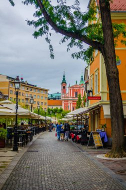 LJUBLJANA, SLOVENIA, 29 Temmuz 2015: Fransisken anonsluk kilisesi ile birlikte Ljubljana 'daki eski kasaba seti. Ljubljana ülkenin iş ve kültür merkezidir..
