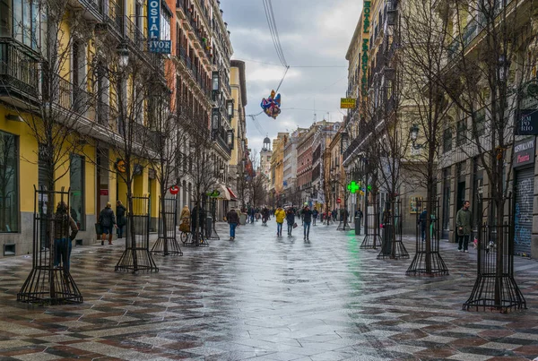 MADRID, SPAIN, HAZİRAN 10 HAZİRAN 2016: İspanya 'nın başkenti Madrid' deki Puerta del Sol Meydanı 'na doğru insanlar Calle de Arenal üzerinde geziniyor