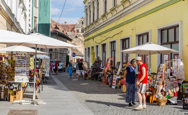 SIBIU, ROMANIA, 6 HAZİRAN 2015: İnsanlar Nicolae Balcescu bulvarı boyunca yürüyor ya da Büyük Meydan 'da güneşli bir günün tadını çıkarıyorlar, üst şehrin en büyük meydanı ve UNESCO tarafından yapılmış bir mimari anıt..