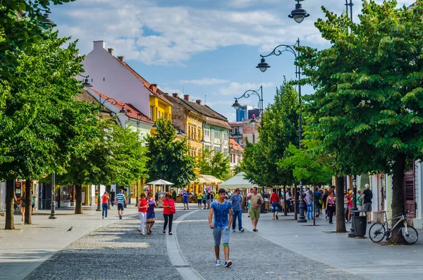 SIBIU, ROMANIA, 6 HAZİRAN 2015: İnsanlar Nicolae Balcescu bulvarı boyunca yürüyor ya da Büyük Meydan 'da güneşli bir günün tadını çıkarıyorlar, üst şehrin en büyük meydanı ve UNESCO tarafından yapılmış bir mimari anıt..