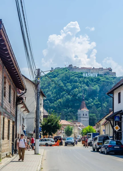 RASNOV, ROMANIA, 8 Temmuz 2015: Tepedeki Ortaçağ kalesi, Rasnov, Transilvanya, Romanya 'daki kasaba adı ve kilisesiyle imzala
