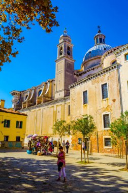 VENICE, ITALY, EPTEMBER 20 EYLÜL 2015: İnsanlar İtalya 'nın Venedik kentindeki Santa Maria del Rosario Kilisesi' ne doğru giden dar bir sokakta geziniyorlar.
