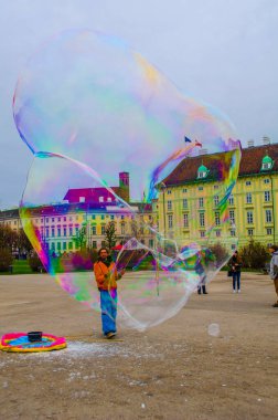 VIENNA, AUSTRIA, DECEMBER 19, 2015: a street performer is creating colorful soap bubbles on the heldenplatz in vienna, austria.