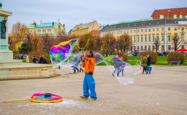 VIENNA, AUSTRIA, 19 ARALIK 2015: Bir sokak sanatçısı Viyana, Avusturya 'da Heldenplatz' da renkli sabun köpükleri yaratıyor.