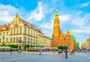 WROCLAW, POLAND, 28 Mayıs 2017: İnsanlar Polonya 'nın merkezindeki güzel Wroclaw meydanı Rynek' teki belediye binasının önünden geçiyor