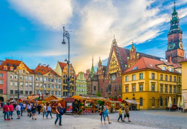WROCLAW, POLAND, 28 Mayıs 2017: İnsanlar Polonya 'nın merkezindeki güzel Wroclaw meydanı Rynek' teki belediye binasının önünden geçiyor