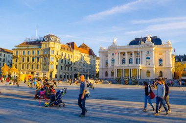 ZURİH, SWitzERLAND, ECTOBER 24, 2015: İnsanlar İsviçre 'nin görkemli opera binasının egemen olduğu Zürih şehrinde sechsenlautenplatz' dan geçiyorlar.