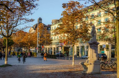 ZURİH, SWitzERLAND, ECTOBER 24, 2015: İnsanlar sonbahar öğleden sonra İsviçre 'de Zürih Gölü boyunca güneşli bir gezinti alanında yürüyorlar