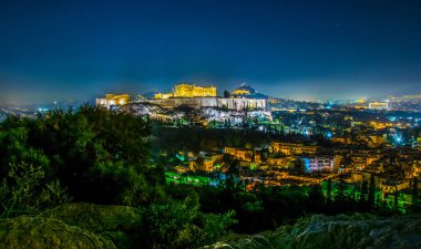 Atina'daki Akropolis Tepesi'nde parthenon ve Herodium inşaatı, Yunanistan gökyüzünde ay ile mavi saat vurdu