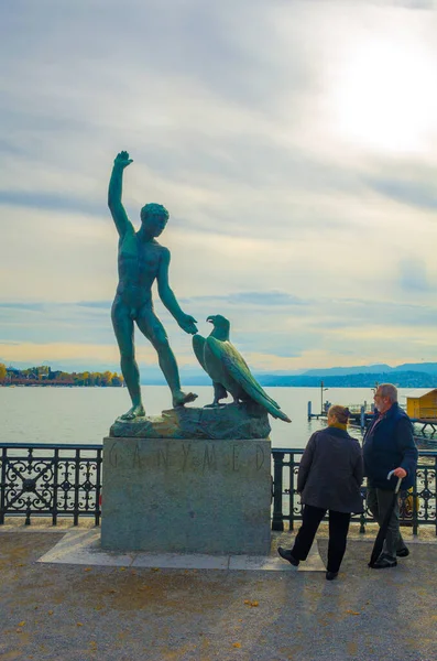 ZURİH, SWitzerland, 24 Ekim 2015: İnsanlar Zürih Gölü 'ne ünlü ganimede heykeliyle bakış açısından hayranlık duyuyorlar