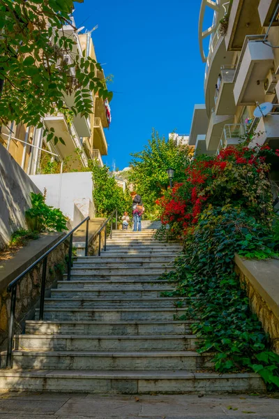 Atina 'daki Lycabetus tepesine çıkan dar bir caddenin manzarası çiçeklerle çevrili uzun bir merdivenle..