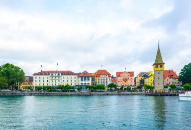 Alman kenti Lindau 'da güneş doğarken meşhur Bayerisches hof binası manzaralı bir liman.
