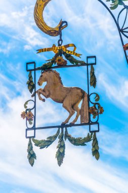 view of an ornamental metal shield hanging in front of a house in central innsbruck, Austria.