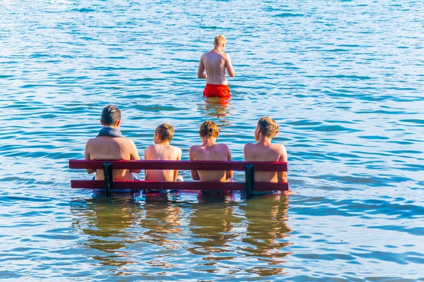 Bir grup çocuk Bodensee, Almanya 'da bir bankta oturuyor.