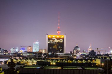 Gece boyunca Reichstag 'ın terasından çekilen Berlin siluetinin görüntüsü. fernsehturm bir alışveriş merkezinin arkasında saklı..