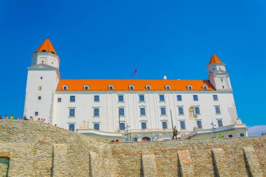 view of the bratislava castle situated on a hill next to the danube river in slovakia