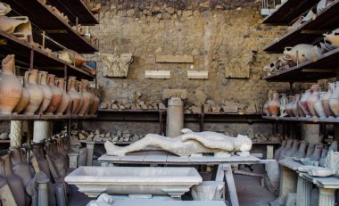 detail of a petrified corpse inside of area of ruins of the pompeii city.