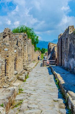 İnsanlar Pompei 'nin tarihi kalıntıları arasında yürüyorlar..