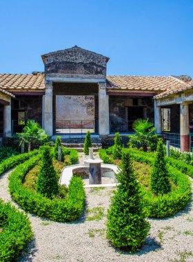 small green courtyard inside of the ruins of pompeii city complex near italian naples.
