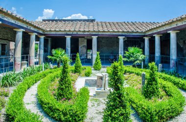 small green courtyard inside of the ruins of pompeii city complex near italian naples.