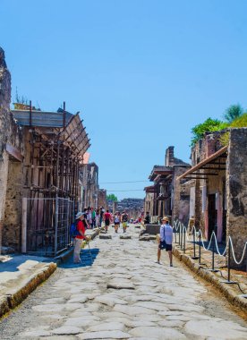 İnsanlar Napoli yakınlarındaki eski İtalyan şehri Pompeii 'nin kalıntılarında yürüyorlar..
