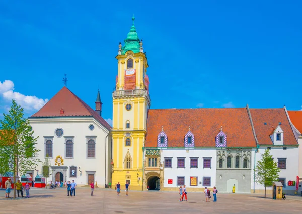 İnsanlar Bratislava 'nın ana meydanındaki belediye binasının önünde geziniyorlar (hlavne name mestie)