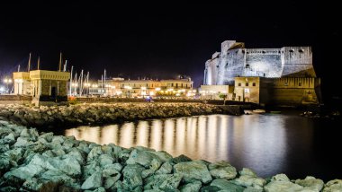 night view of illuminated Castel dell'Ovo (Egg Castle) a medieval fortress in the bay of Naples, Italy