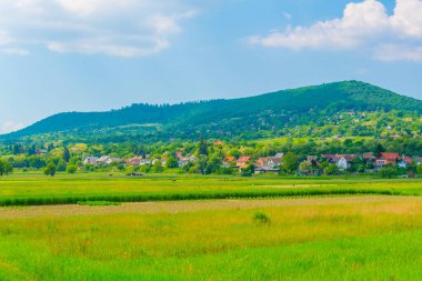 Tarlalar ve tepeler arasında yuva yapmış küçük bir Macar köyü.