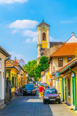 view of a narrow street in the hungarian city szentendre with tower of the blagovestenska church on background.