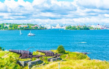 Suomenlinna Adası 'nda Helsinki, Finlandiya' nın arka planında bulunan eski bir top.