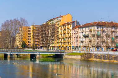 İtalyan Torino şehrindeki Dora Riparia nehrinin nehir kenarına uzanan tarihi binalar..