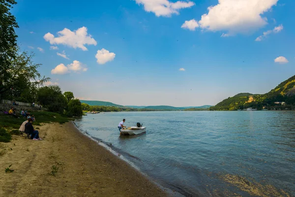 İnsanlar Macaristan 'daki Danube nehrinin kıvrımlarındaki kumlu sahilde güneşli bir günün tadını çıkarıyorlar.