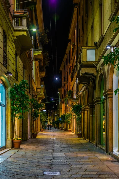 İtalya 'nın Milano şehrinde aydınlık dar bir caddenin gece görüşü.