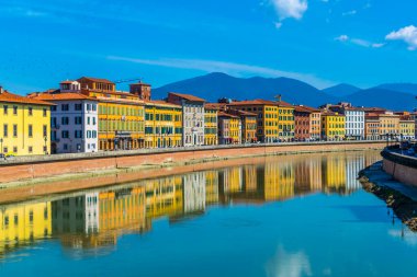 İtalyan şehri Pisa 'nın tarihi merkezinde Arno nehri boyunca uzanan tarihi binalar..