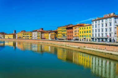 İtalyan şehri Pisa 'nın tarihi merkezinde Arno nehri boyunca uzanan tarihi binalar..