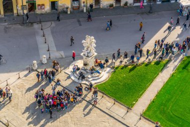 Pisa 'daki meydanda güneşli günün keyfini çıkaran insanların hava manzarası. Meşhur eğik kule nerede?.