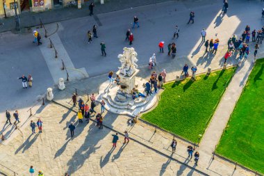 aerial view of people enjoying sunny day on the piazza die miracoli in Pisa where is the famous leaning tower situated.