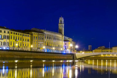 İtalyan şehri Pisa 'nın tarihi merkezinde Arno nehri boyunca uzanan tarihi binaların gece manzarası.