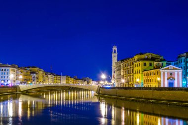 İtalyan şehri Pisa 'nın tarihi merkezinde Arno nehri boyunca uzanan tarihi binaların gece manzarası.